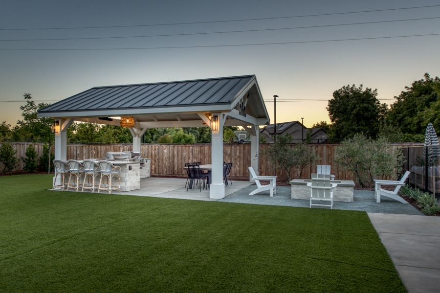 16x20 Timber Frame Pavilion and Patio at night by outdoor fire pit area
