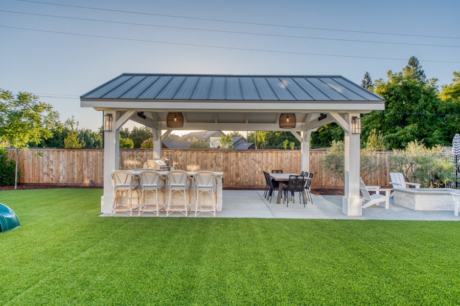 16x20 Timber Frame Pavilion and Patio with dark gray metal roofing and outdoor kitchen and seating area