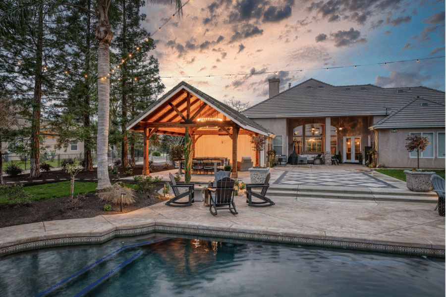 17x23 timber frame pavilion lit up at night by pool