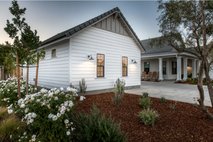 20x24 white and black metal roofed 2-car garage by flower bed