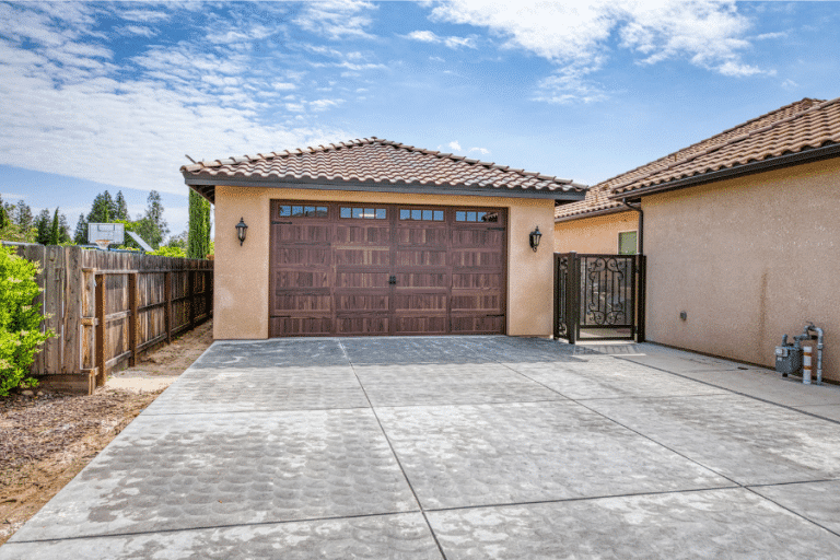 22x34 Garage With Spanish Tile roof, stucco siding, and brown overhead garage door
