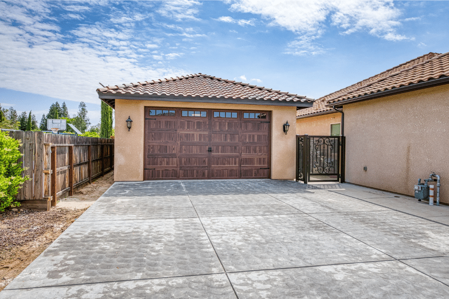 22x34 Garage With Spanish Tile roof, stucco siding, and brown overhead garage door