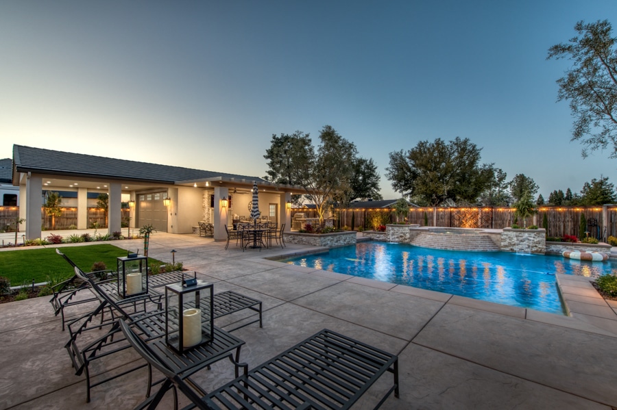30x50 2-car garage with attached patio by pool lit up at night