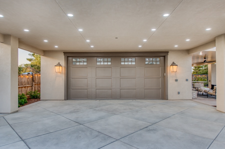 30x50 garage with brown overhead door with transom windows and overhang with lighting on underside