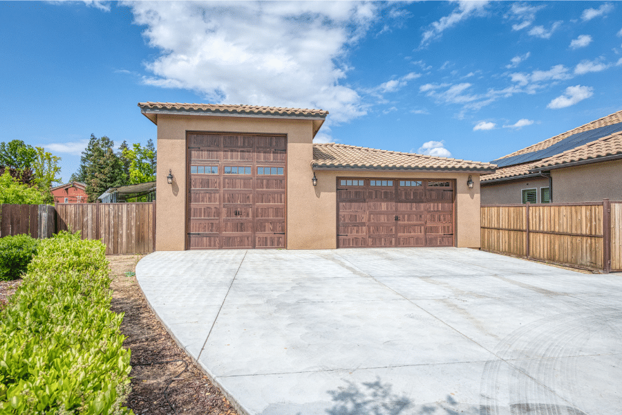 32x40 garage with spanish tile roofing and two wood grain garage doors