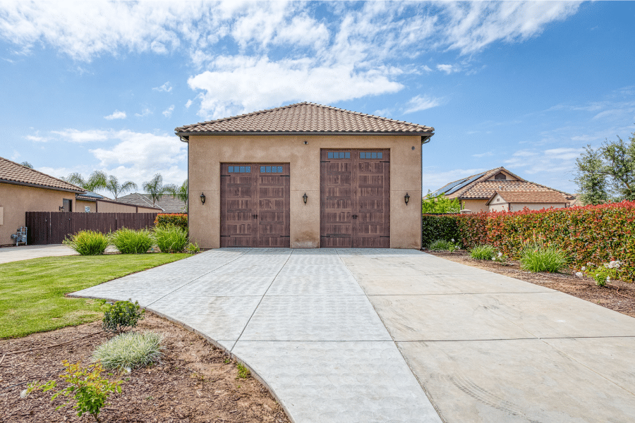 32x50 Garage with spanish tile roof and two closed wood-grain garage doors of different sizes