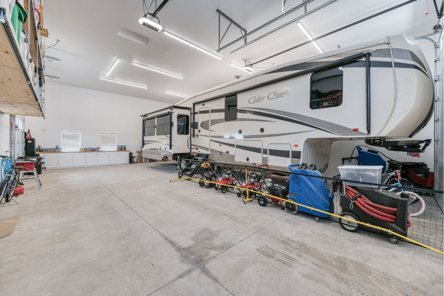 RV, shelving, and workbench inside custom 32x50 garage with spanish tile