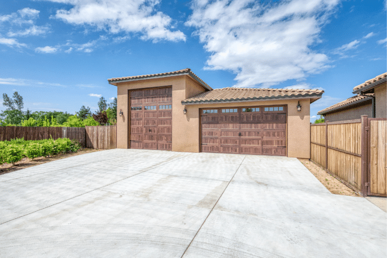 Tan stucco-sided 3-car 32x40 Garage With Spanish Tile Roofing featuring 14' door for RV storage