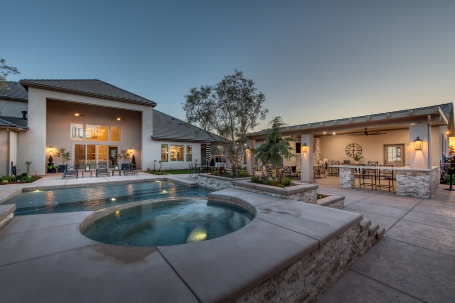attached patio of 30x50 garage by pool lit up at night
