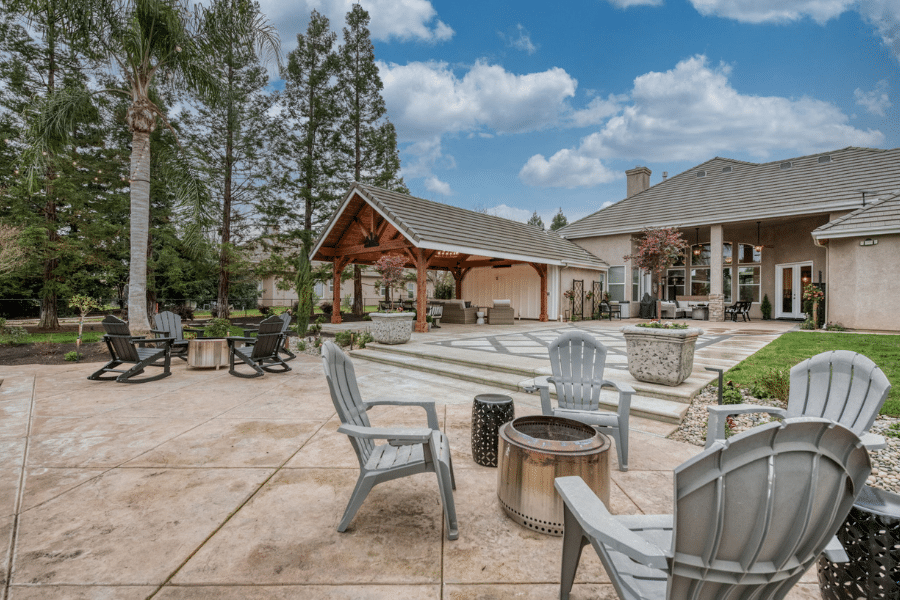 backyard in Clovis, CA during the day with fire pits, concrete patio, and 17x23 timber frame pavilion