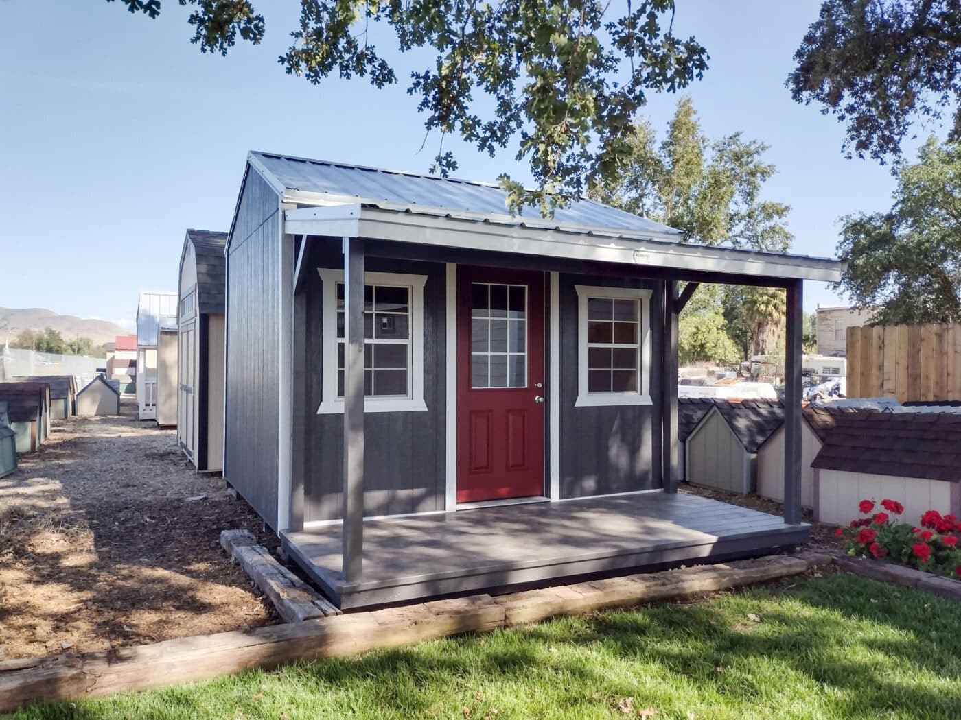blue storage buildings for sale in Auberry CA with white trim front porch and red door