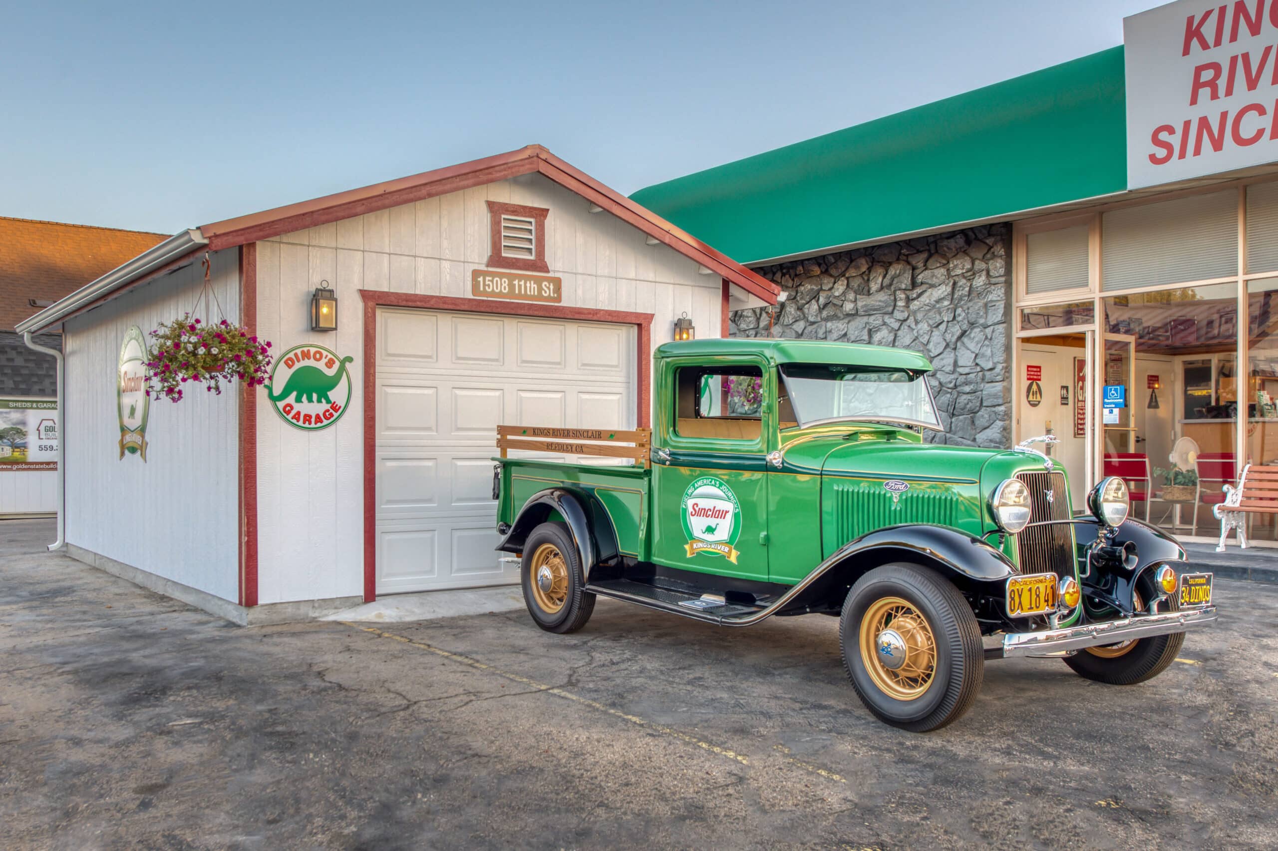 custom white and red trimmed one car garage with green truck parked in front by business with same colors
