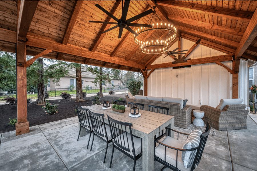 dining table, fans, and chandelier in 17x23 timber frame pavilion