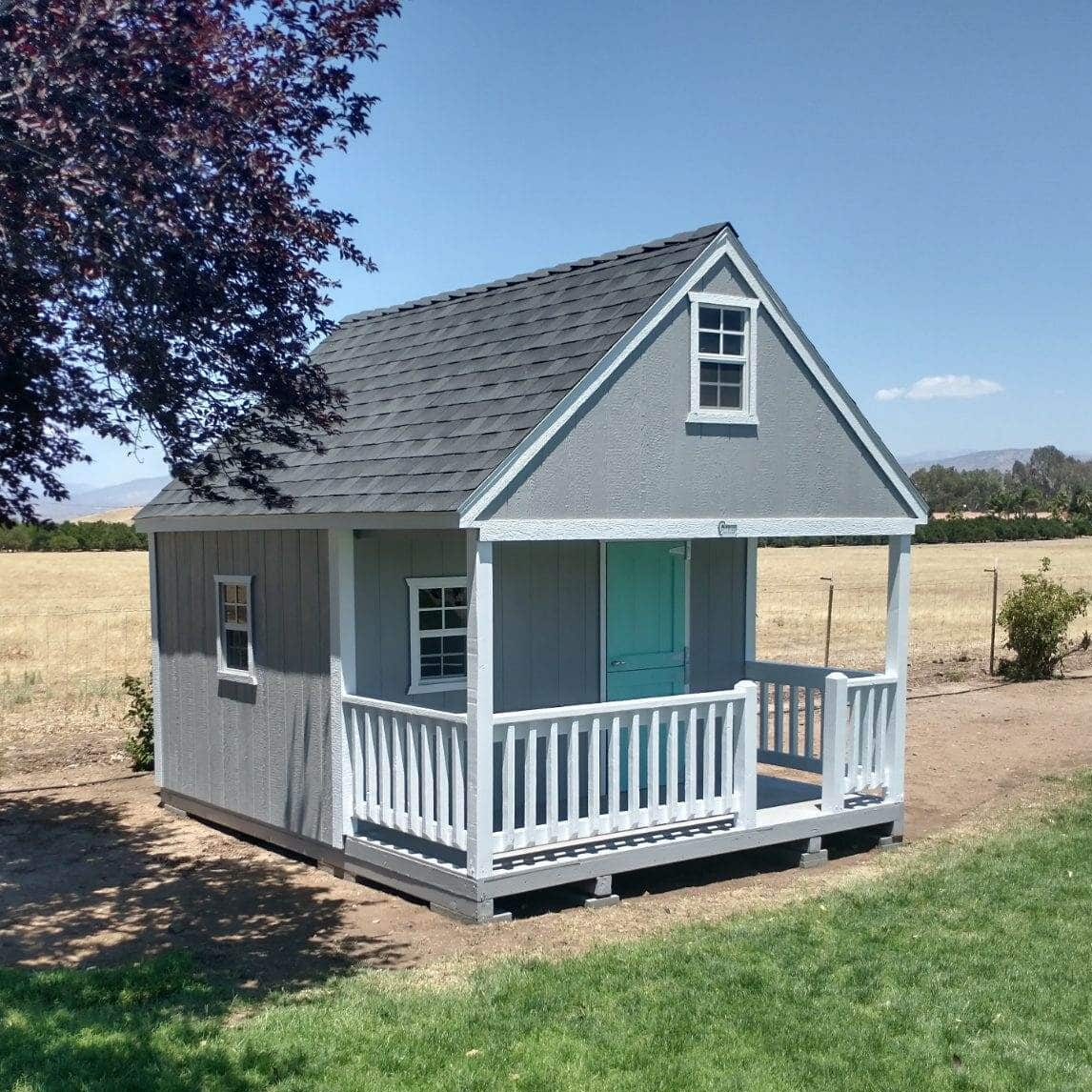 gray children's playhouse with white front porch and teal front door