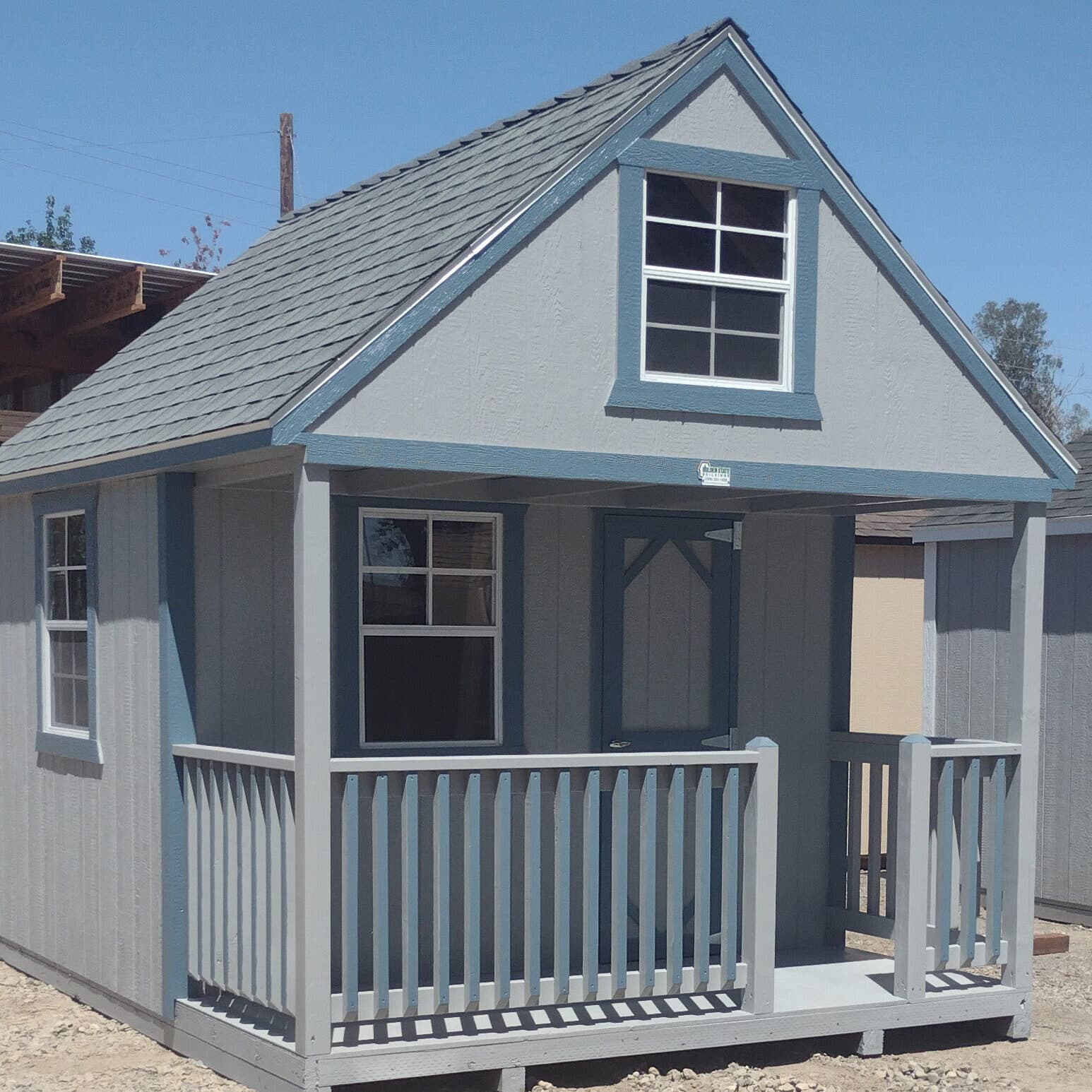 gray playhouse with teal trim and front porch