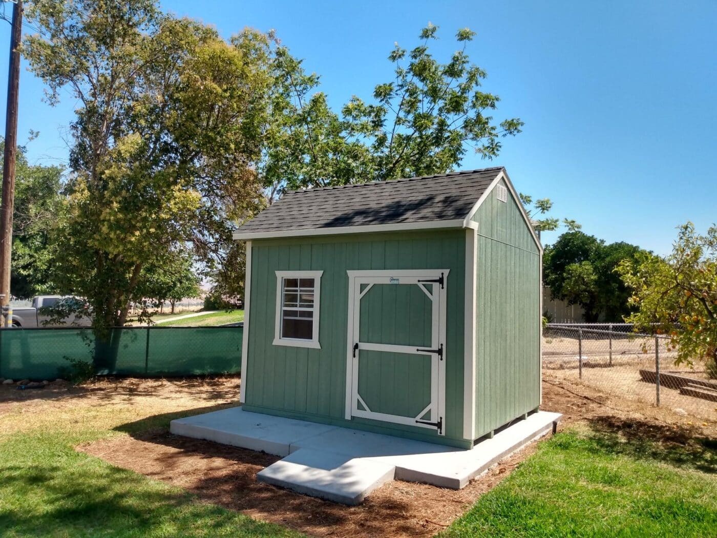 green and white trimmed storage buildings for sale near Coarsegold CA on concrete pad
