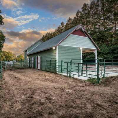 green horse barn with fence and horses in dunlap ca