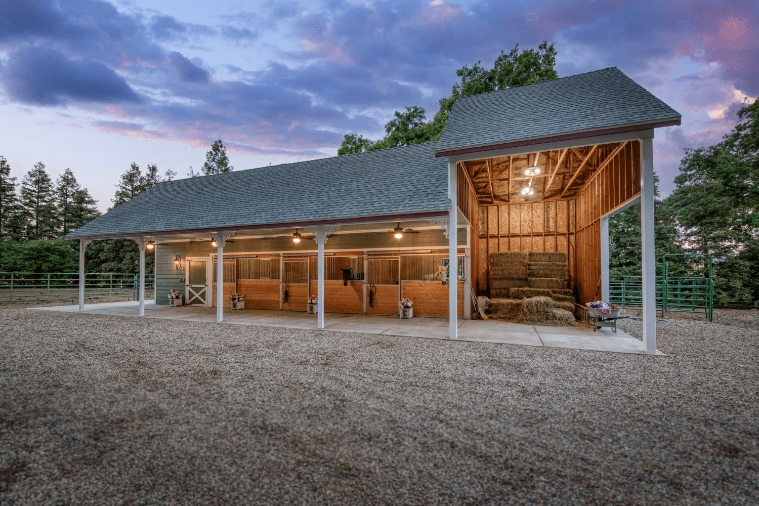green horse barn with horses