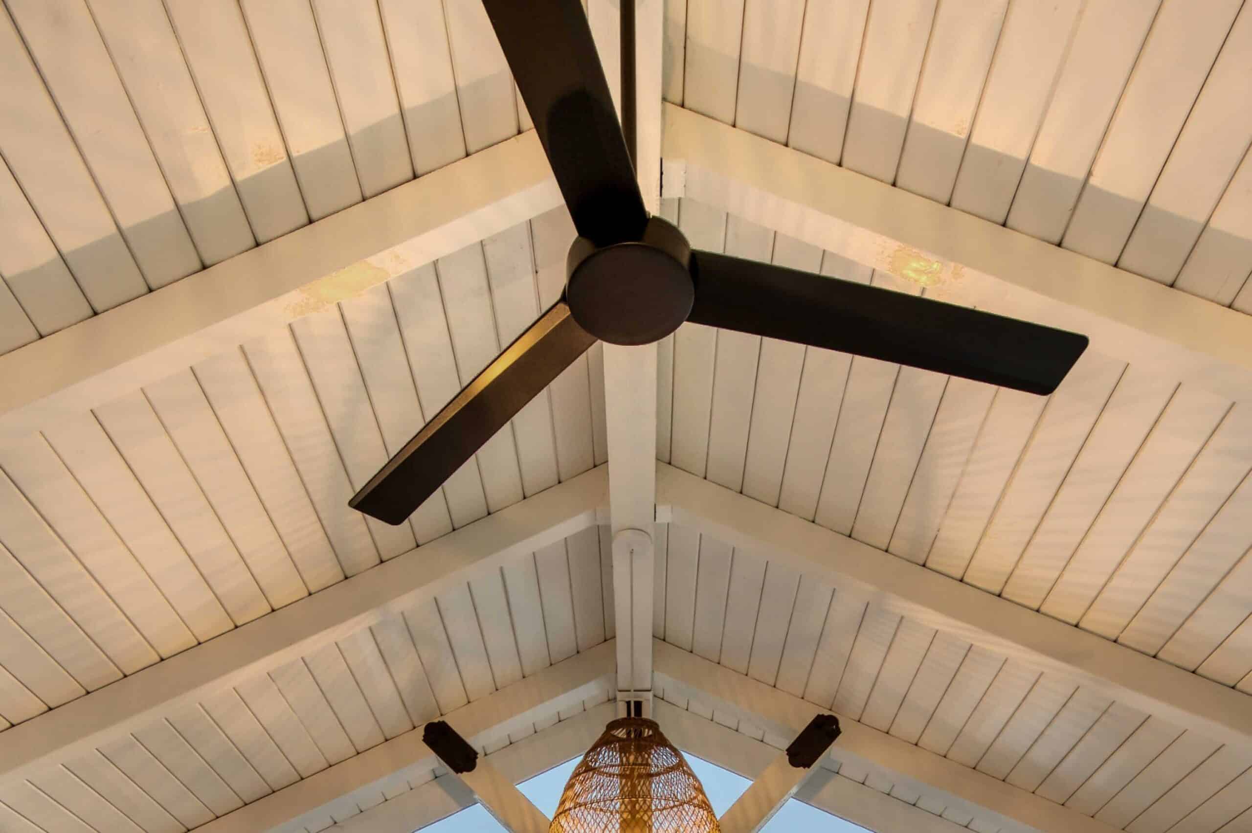lights and fans over table with chairs underneath white pavilion on concrete pad