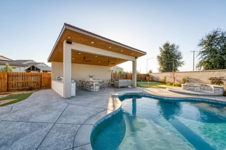 poolside pavilion with seating area and kitchen and lighting in the roof above
