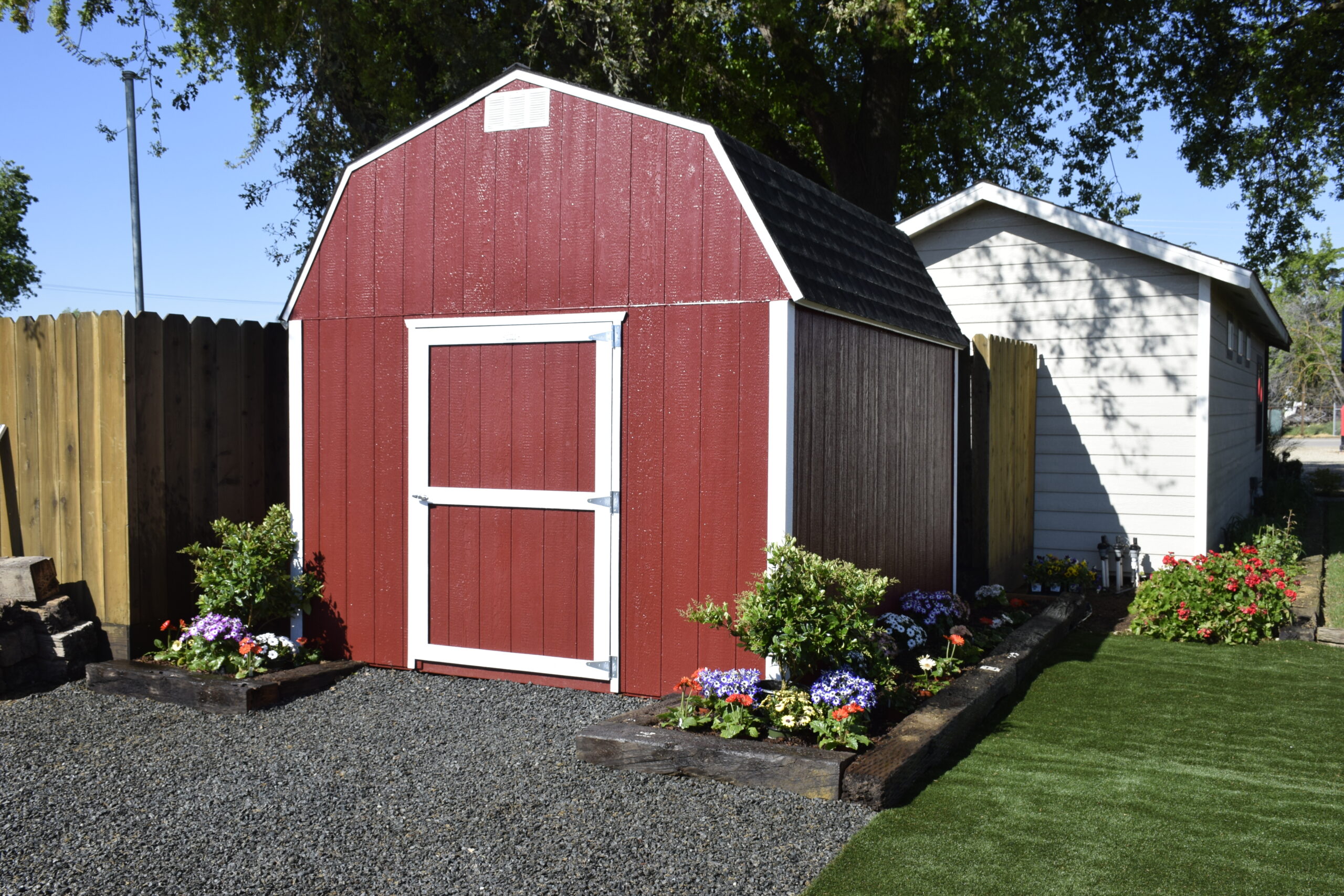 red and white trimmed value stormax with garden bed around it