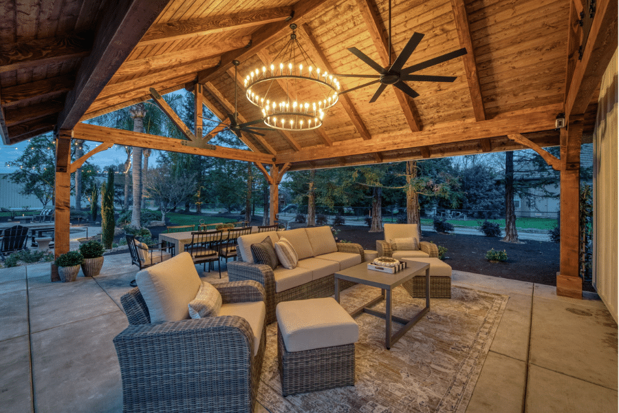 seating area with lighting at night in timber frame pavilion