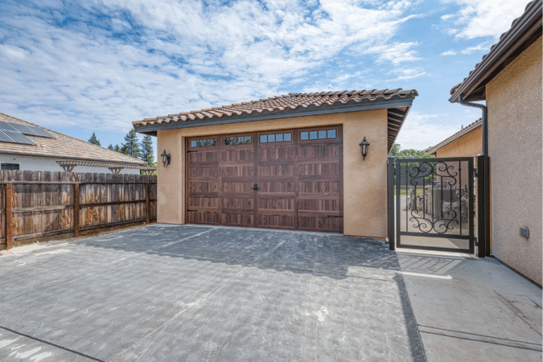 side view of 22x34 garage with spanish tile roof along fence
