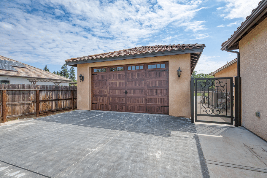 side view of 22x34 garage with spanish tile roof along fence