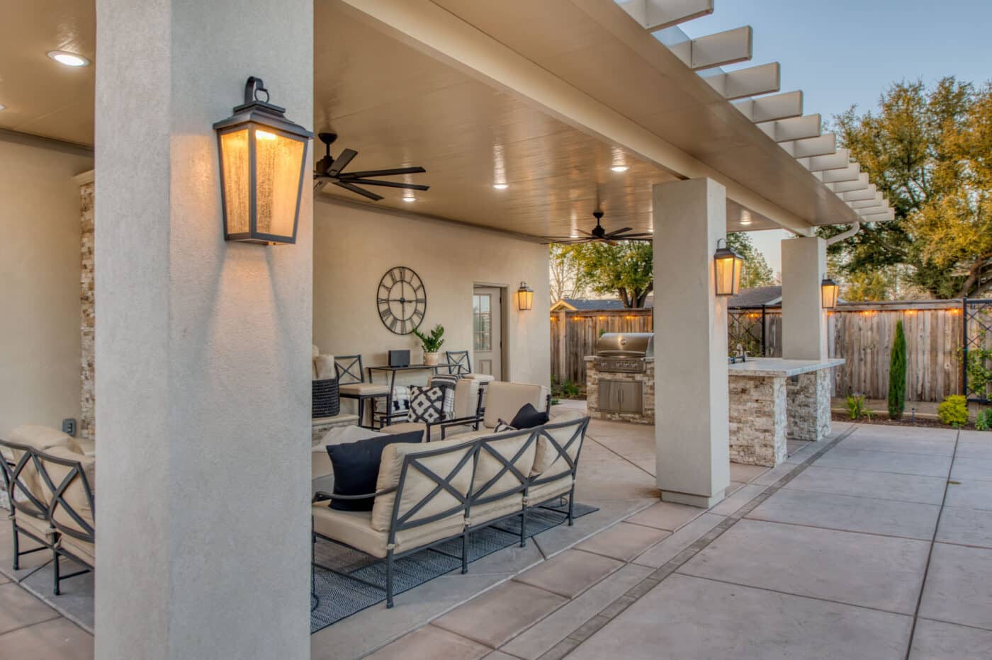side view of custom pavilion with lighting fans seating area and marble countertops and grill set up