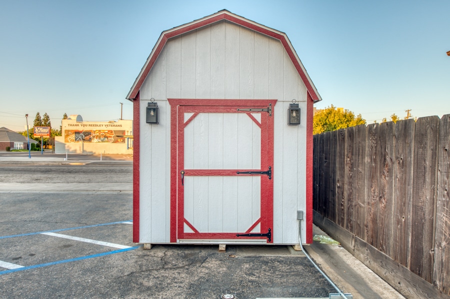 tan and red trimmed barn style shed