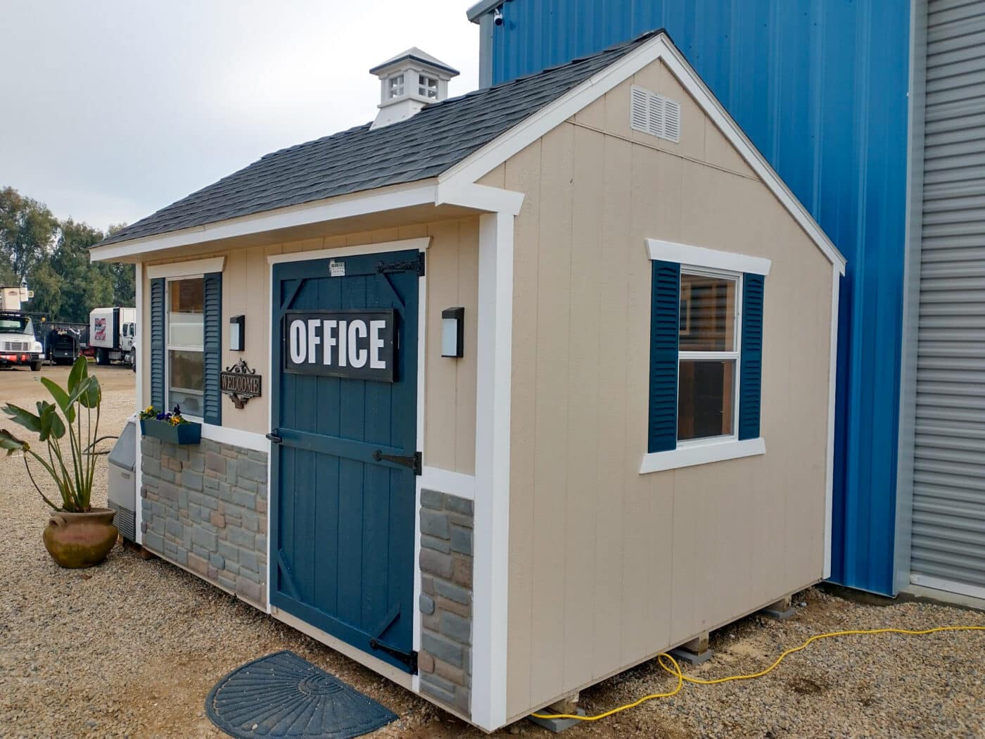 tan customs hed with blue door titled office