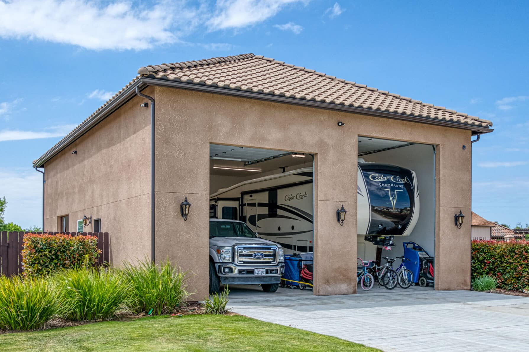 tan two car garage with different sized doors to fit truck and a trailer