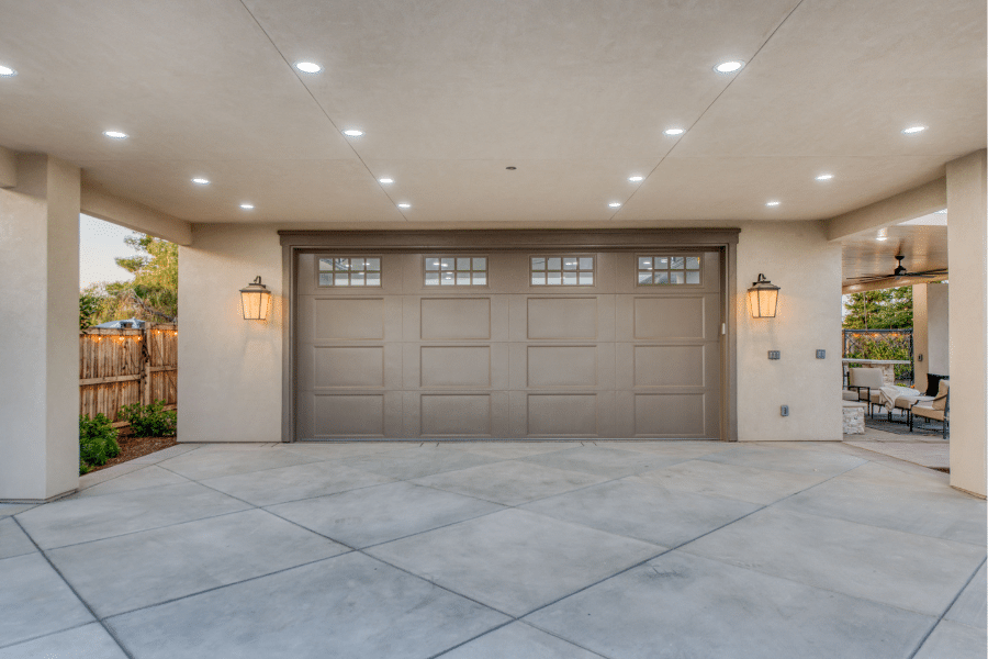 tan two car garage with overhang and lights