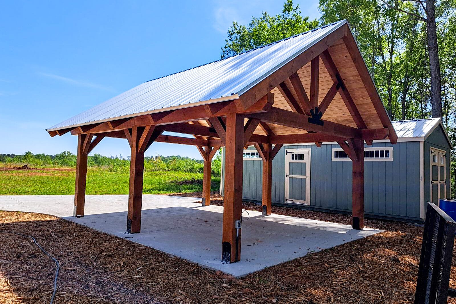 timber frame pavilion on concrete pad in mulch