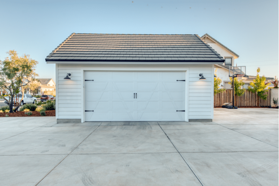 white 20x24 2-car detached garage with black metal roofing and single white overhead door