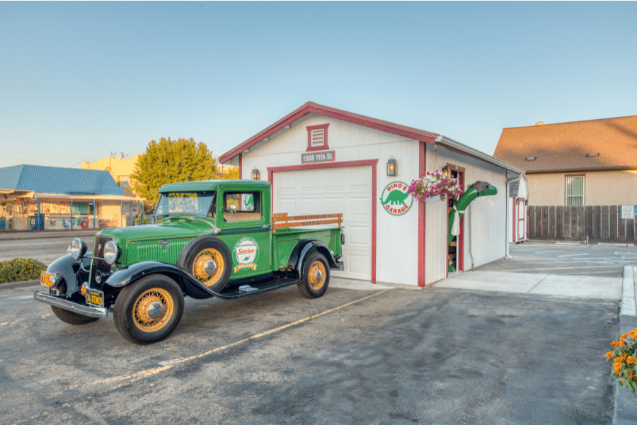 white and red trimmed 14x20 garage with restored green Sinclair ford and Sinclair dino poking head out side door in reedley, CA
