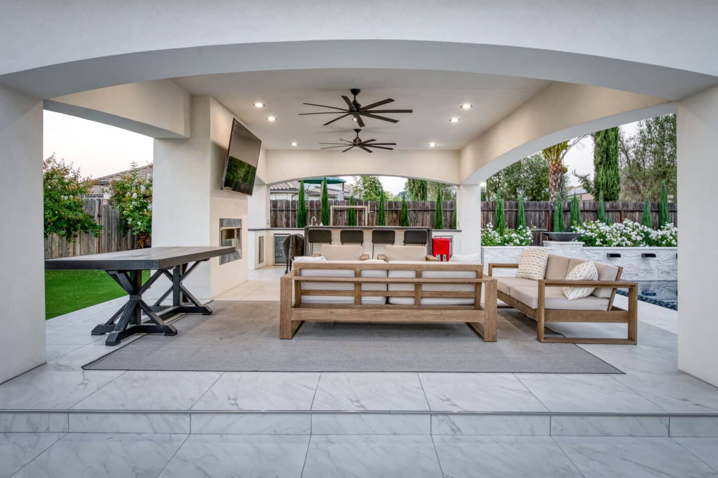 white siding on pavilion with fans lights TV firepit seating are and bartop seating